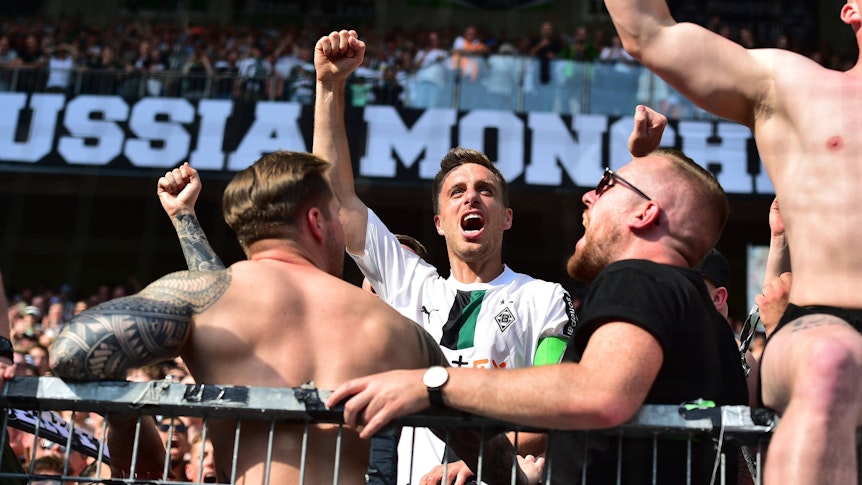 Patrick Herrmann steht in der Borussia-Kurve und jubelt.