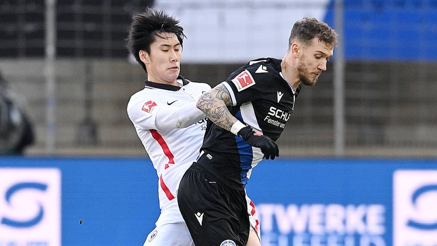 Daichi Kamada im Zweikampf mit Marcel Hartel.