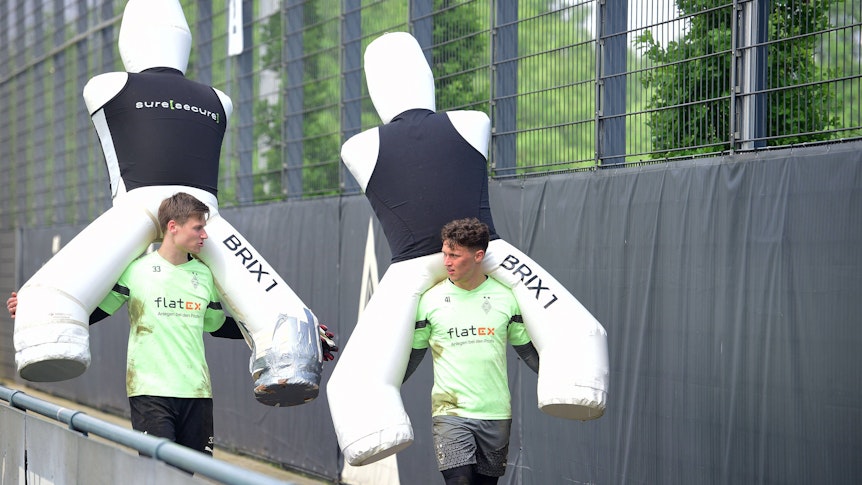 Moritz Nicolas und Jan Olschowsky tragen große Aufsteller für das Training auf ihren Schultern.