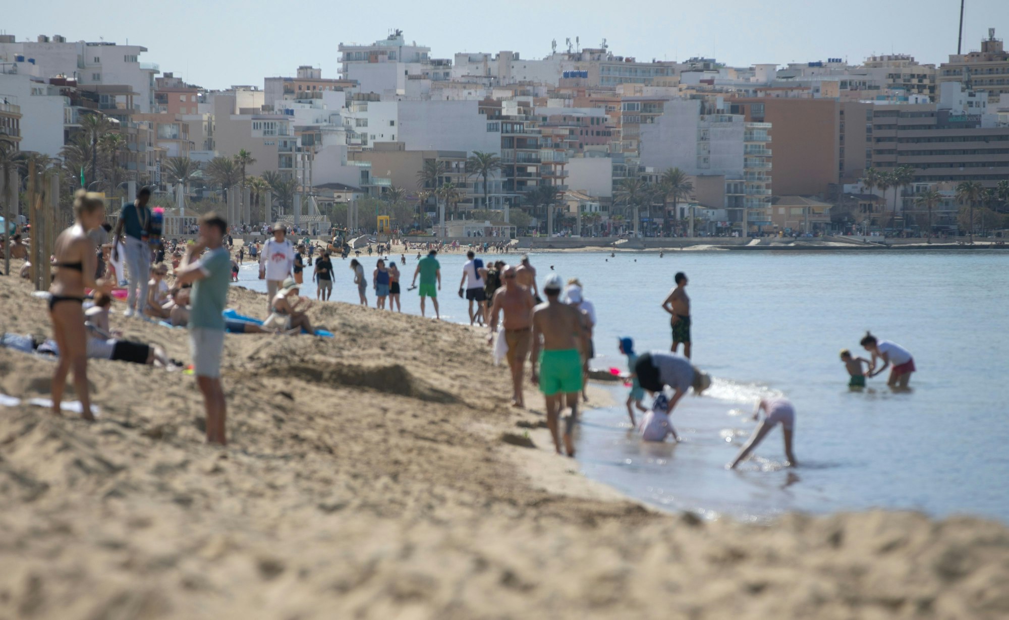 Menschen spazieren am Strand von Arenal auf Mallorca.