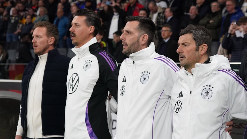 Das Trainerteam des DFB bei der Hymne.