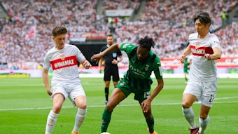 Nathan Ngoumou gegen zwei Stuttgart-Spieler.