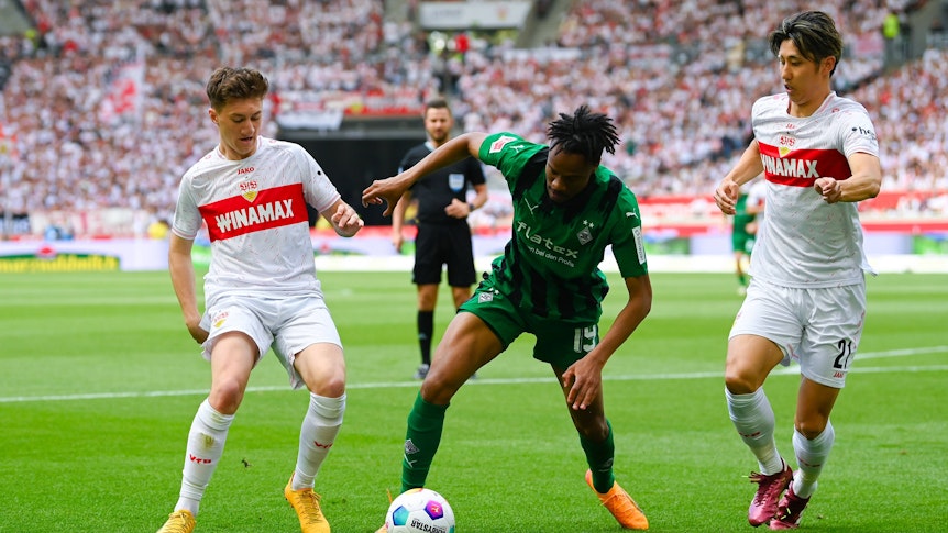 Nathan Ngoumou gegen zwei Stuttgart-Spieler.