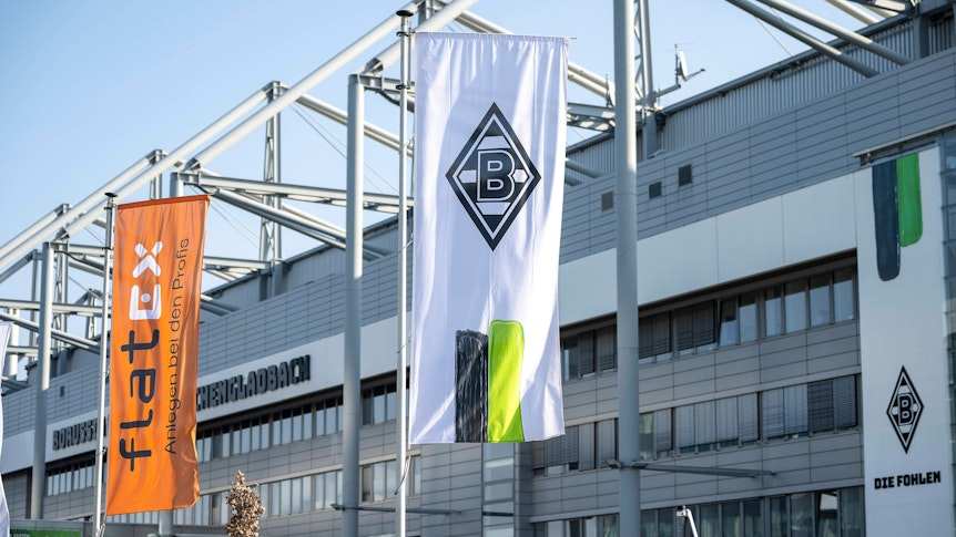 Eine Borussia-Fahne und eine Sponsoren-Flagge vor dem Borussia-Park.