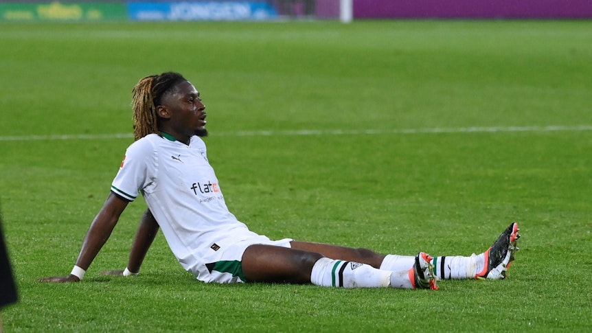 Manu Koné sitzt am Boden.