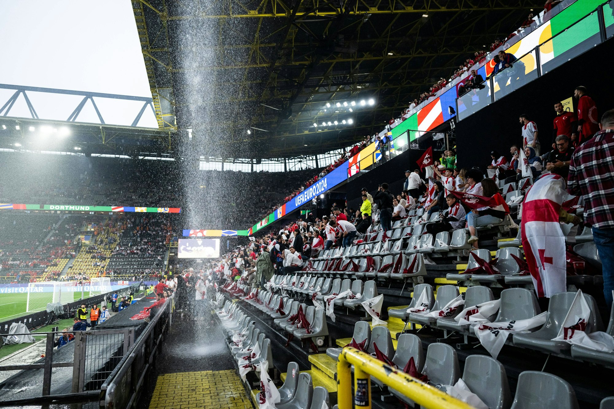 Ein Wasserfall prasselt vom Dach des Stadions in Dortmund auf die Fan-Tribüne.