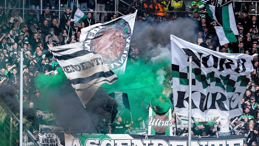Fans von Borussia Mönchengladbach zünden während des Bundesliga-Spiels bei der TSG Hoffenheim im Gäste-Block Pyrotechnik.