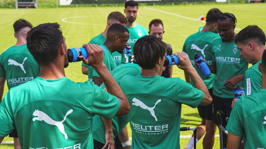 Die Spieler von Borussia Mönchengladbach trinken aus ihren Wasserflaschen.