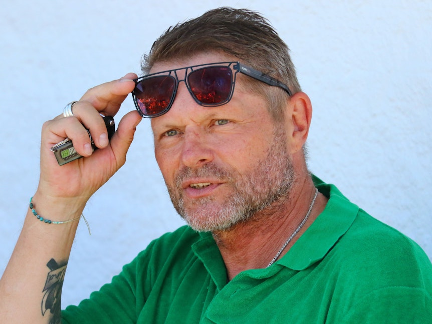 Uli Borowka schiebt sich die Sonnenbrille auf die Stirn.