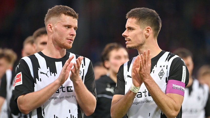 Die Mönchengladbach-Profis Nico Elvedi und Julian Weigl stehen nebeneinander auf dem Platz und applaudieren den Fans.