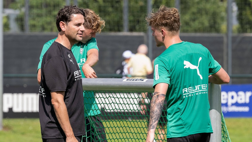 Gerardo Seoane und Luca Netz tragen ein kleines Tor beim Training.