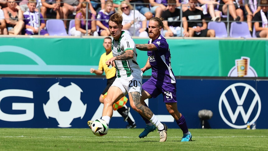 Borussia Mönchengladbachs Luca Netz passt den Ball, Aues Marvin Stefaniak verfolgt ihn.