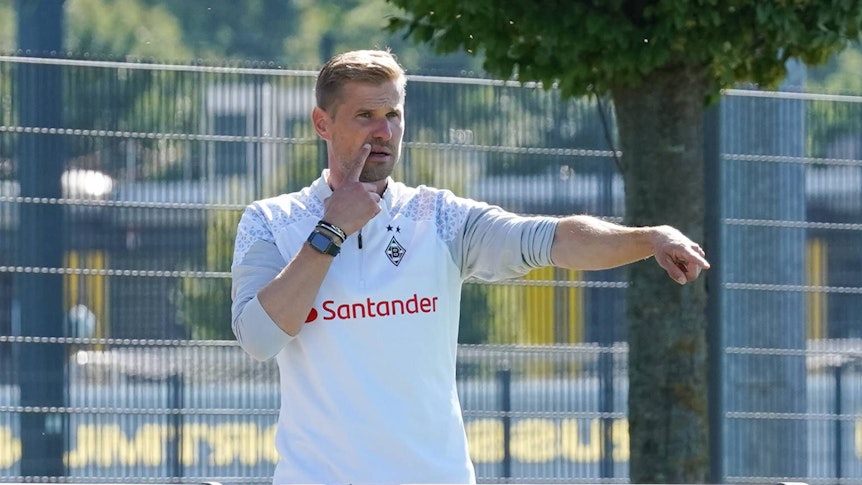 Oliver Kirch hebt den rechten Arm und zeigt etwas an.