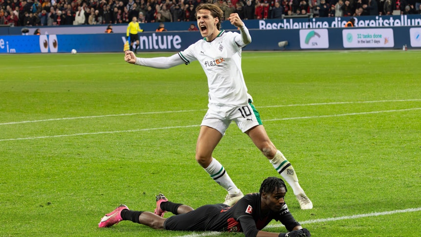 Florian Neuhaus bejubelt eine Grätsche gegen Jeremie Frimpong, der am Boden liegt.