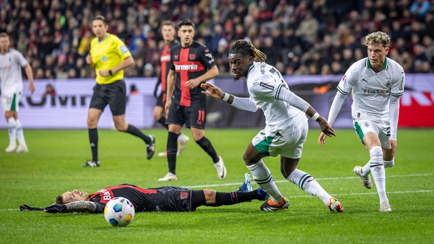 Manu Koné dribbtel Leverkusens Grimaldo aus, der am Boden liegt.
