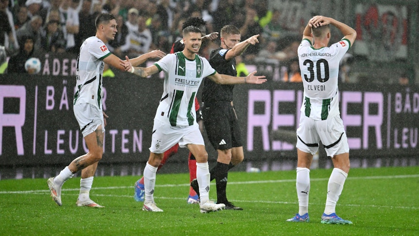 Die Gladbach-Profis Tomas Cvancara, Julian Weigl und Nico Elvedi reagieren im Spiel gegen Leverkusen entsetzt auf den Elfmeterpfiff des Schiedsrichters Robert Schröder.