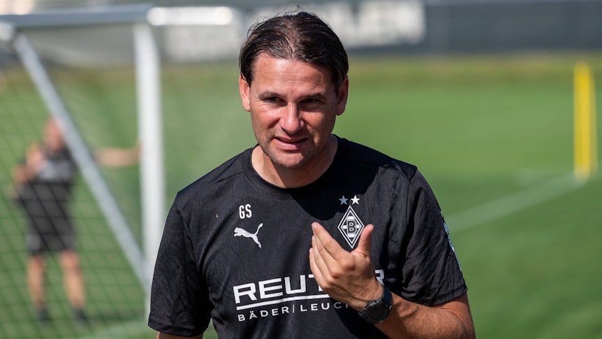 Borussia Mönchengladbachs Trainer Gerardo Seoane läuft auf den Trainingsplatz und blickt in die Kamera.