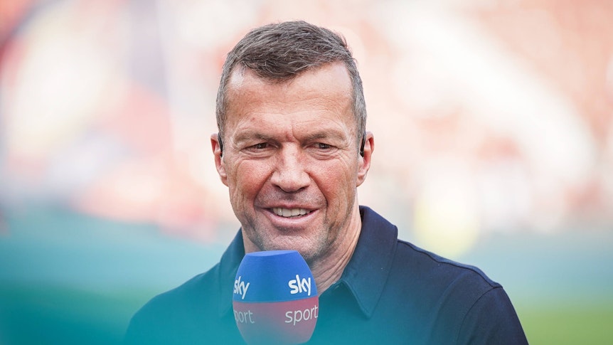 Sky-Experte Lothar Matthäus spricht beim Spiel Bayer Leverkusen gegen RB Leipzig lächelnd ins Mikrofon.