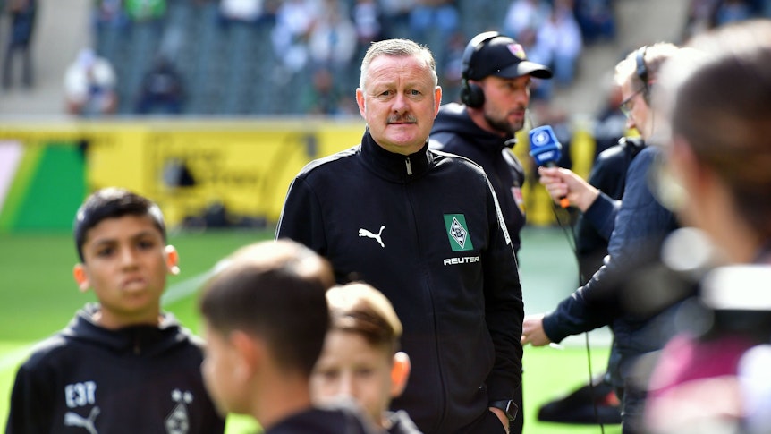 Gladbach-Boss Roland Virkus blickt auf die Tribüne.