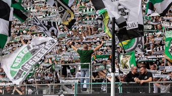 Die Fans in der Nordkurve heben den Schal in die Höhe.