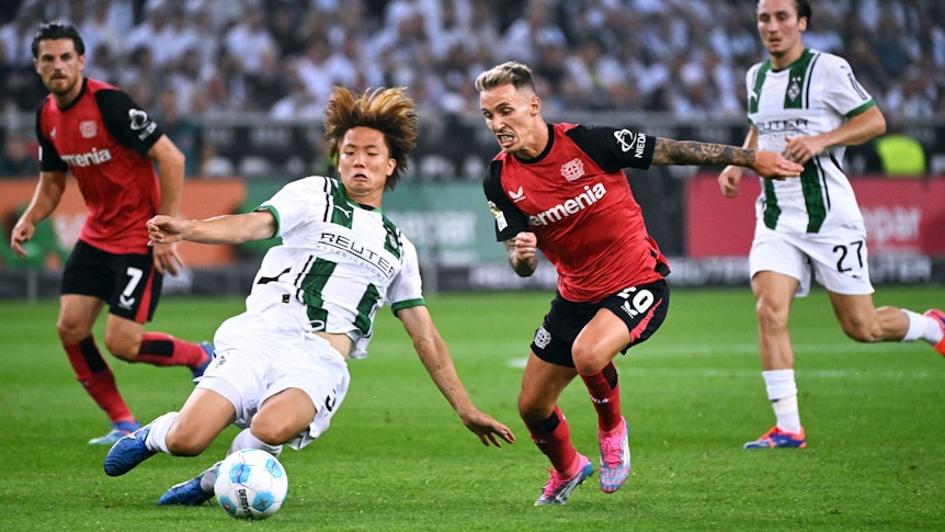 Borussia Mönchengladbachs Ko Itakura grätscht gegen Bayer Leverkusens Alejandro Grimaldo.