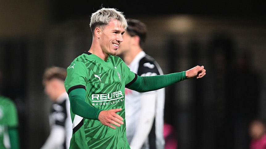 Noah Pesch lächelt im Gladbach-Trikot.