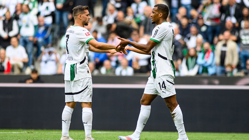 Kevin Stöger und Alassane Plea klatschen sich auf dem Spielfeld ab.