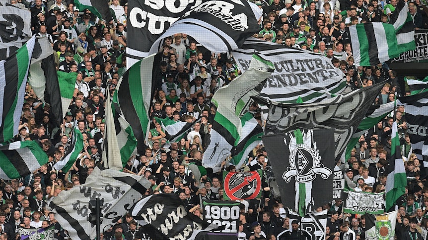 Fans von Borussia Mönchengladbach schwenken beim Bundesliga-Heimspiel gegen den 1. FC Heidenheim in der Nordkurve ihre Fahnen.
