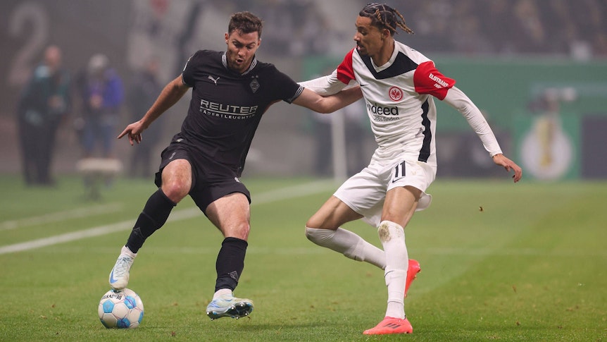 Borussia Mönchengladbachs Joe Scally und Eintracht Frankfurts Hugo Ekitiké kämpfen um den Ball.