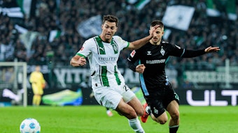 Borussia Mönchengladbachs Joe Scally und Werder Bremens Romano Schmid kämpfen um den Ball.