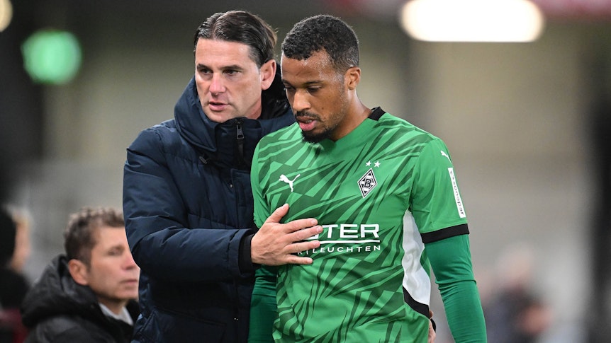 Borussia Mönchengladbachs Trainer Gerardo Seoane nimmt seinen Stürmer Alassane Plea im Testspiel beim SC Verl an der Seitenlinie in den Arm.