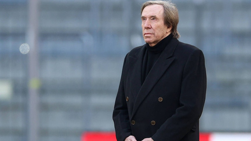 Günter Netzer im schwarzen Mantel in der Allianz-Arena.
