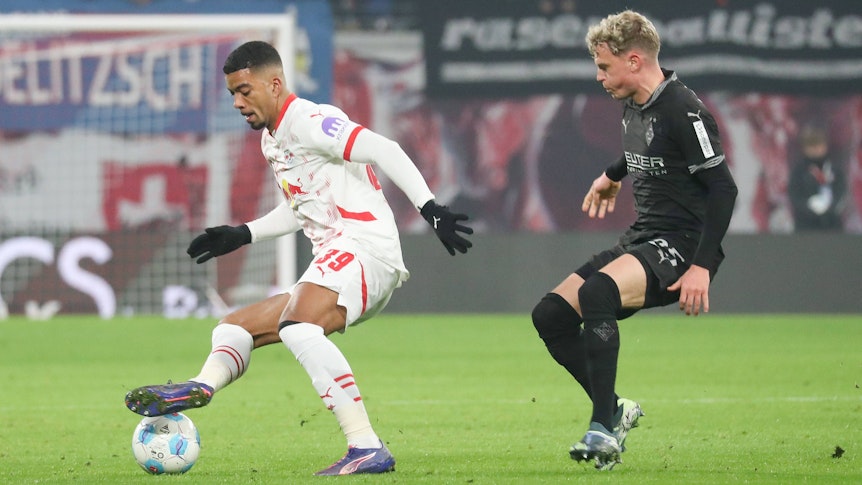 Borussia Mönchengladbachs Robin Hack kämpft mit RB Leipzigs Benjamin Henrichs um den Ball.