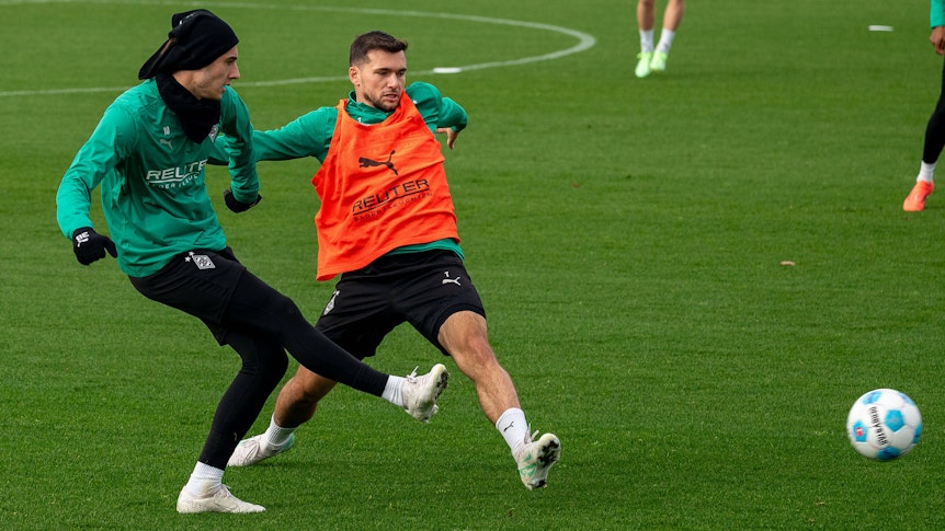Borussia Mönchengladbachs Florian Neuhaus passt den Ball im Training, Teamkollege Kevin Stöger versucht zu blocken.