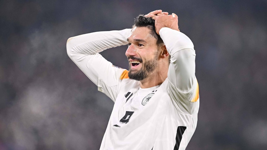 Deutschlands Nationalspieler Tim Kleindienst schlägt im Spiel gegen Bosnien-Herzegowina lachend die Hände über dem Kopf zusammen.