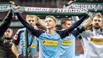 Oscar Wendt hält einen Borussia-Schal hoch.