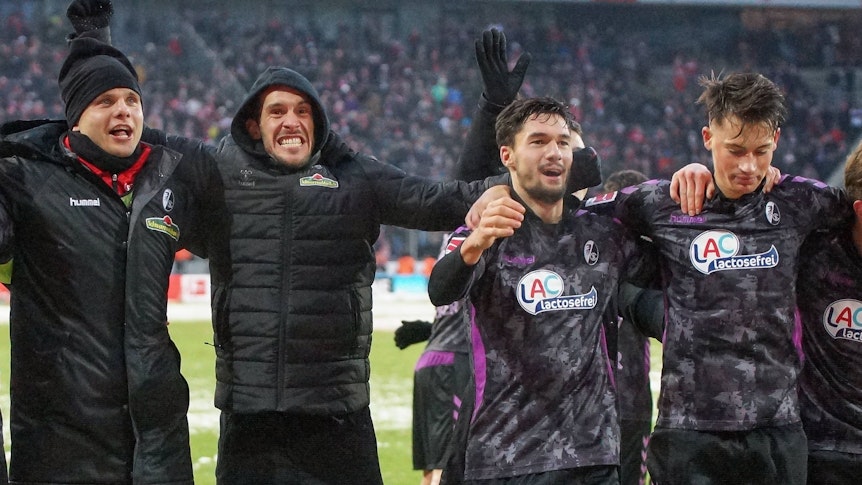Die Freiburger Profis Rafal Gikiewicz, Julian Schuster, Tim Kleindienst und Robin Koch feiern mit den Fans vor der Kurve nach dem Spiel beim 1. FC Köln.