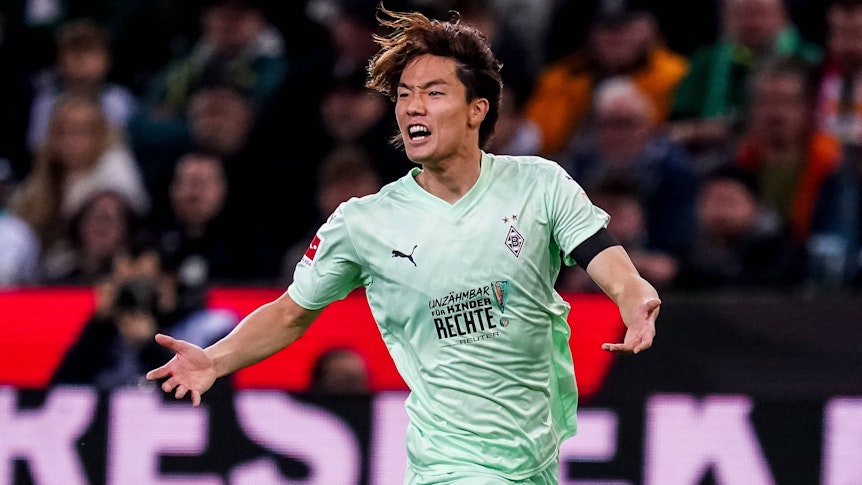 Ko Itakura schreit lauthals auf dem Platz und breitet seine Arme dabei aus.