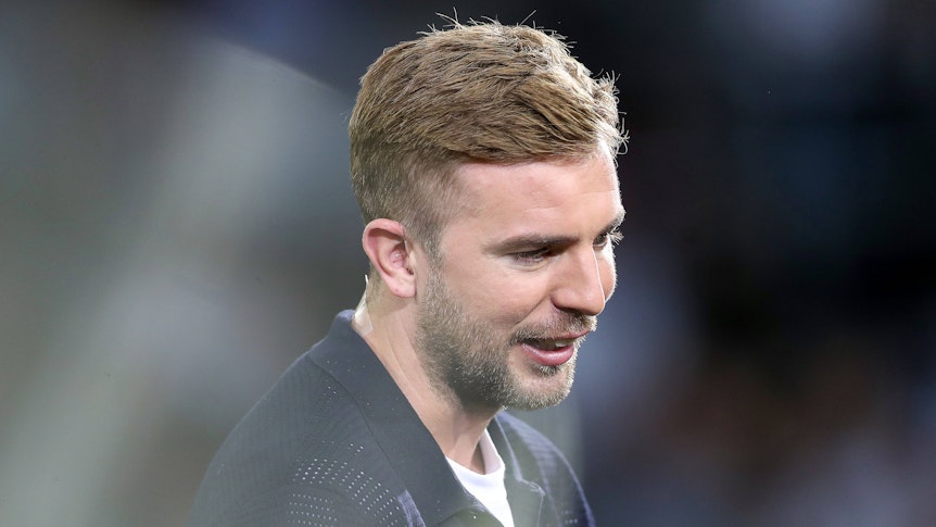 TV-Experte Christoph Kramer steht beim Nations-League-Spiel Deutschland gegen Ungarn im Stadion und lächelt.