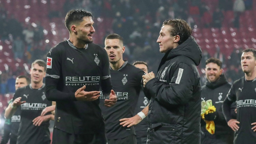 Die Gladbach-Profis Tim Kleindienst und Rocco Reitz unterhalten sich nach dem Spiel bei RB Leipzig auf dem Platz.