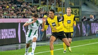 Borussia Mönchengladbachs Kevin Stöger kämpft mit Borussia Dortmunds Felix Nmecha um den Ball.
