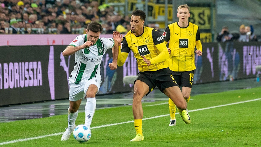 Borussia Mönchengladbachs Kevin Stöger kämpft mit Borussia Dortmunds Felix Nmecha um den Ball.