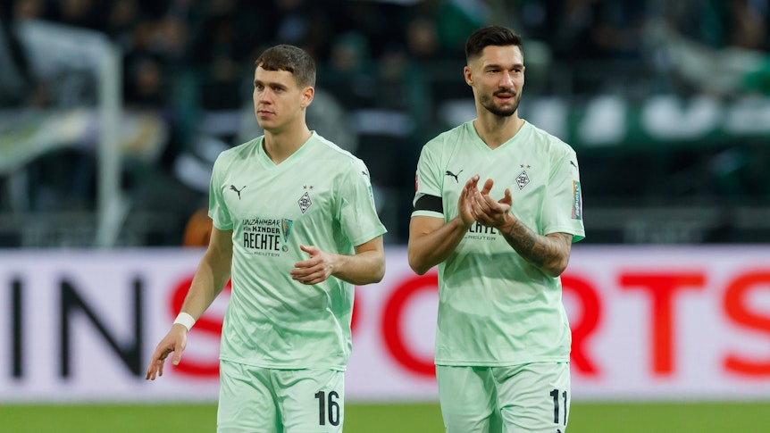 Die Gladbach-Profis Philipp Sander und Tim Kleindienst laufen nach dem Spiel gegen den FC St. Pauli nebeneinander über den Platz.