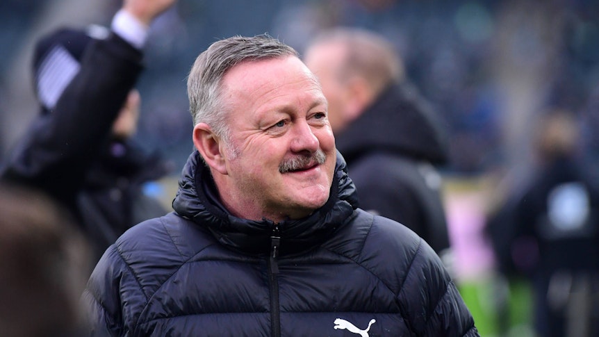 Roland Virkus grinst vor einem Spiel in der Bundesliga.