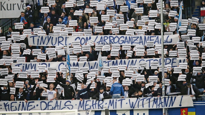 Mehrere Hoffenheim-Fans halten Protest-Schilder hoch.