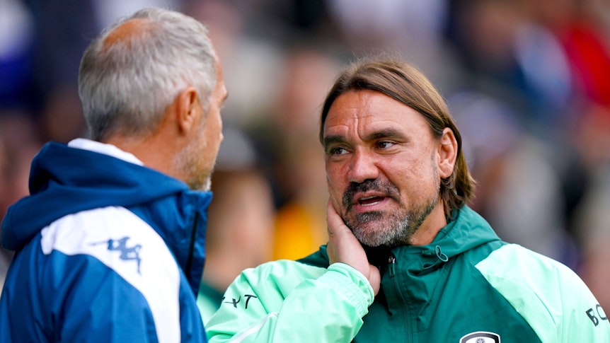Daniel Farke unterhält sich in Regenjacke mit Adi Hütter am Seitenrand.