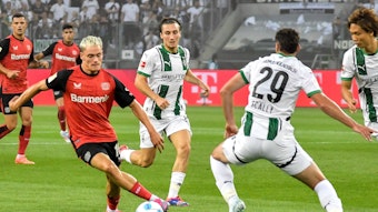 Spieler von Borussia Mönchengladbach im Kampf um den Ball gegen Florian Wirtz.