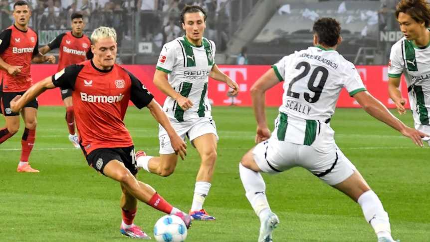 Spieler von Borussia Mönchengladbach im Kampf um den Ball gegen Florian Wirtz.