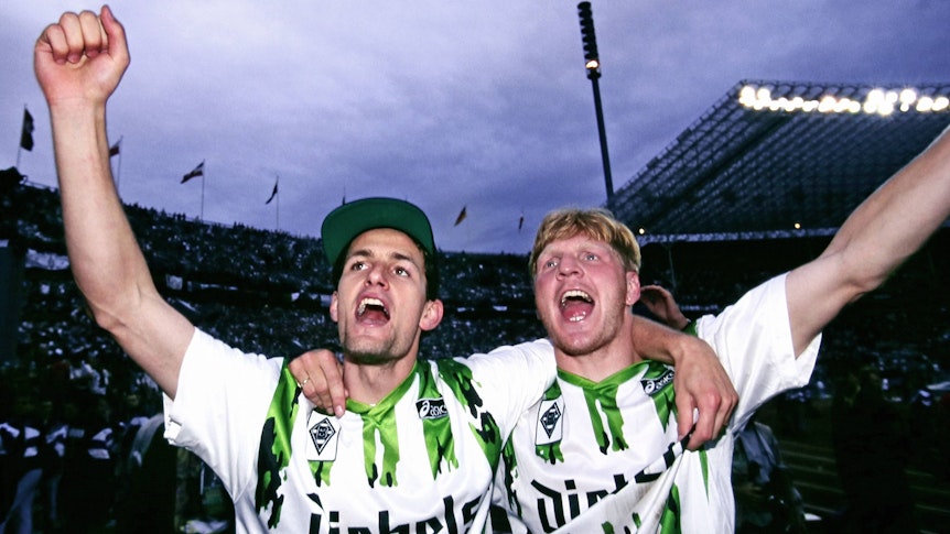 Heiko Herrlich und Stefan Effenberg jubeln nach dem Gewinn des DFB-Pokals mit Borussia Mönchengladbach Arm in Arm vor den Fans.