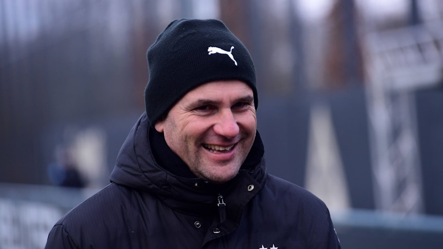 Borussia Mönchengladbachs Trainer Gerardo Seoane läuft lachend auf den Trainingsplatz.